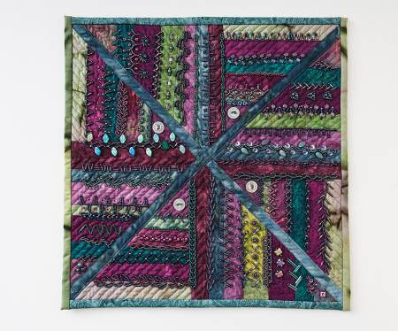Quilted square with colorful fabric and decorative stitching.