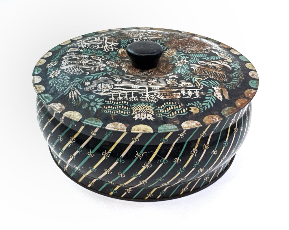 Round tin with lid, black with decorative patterns.