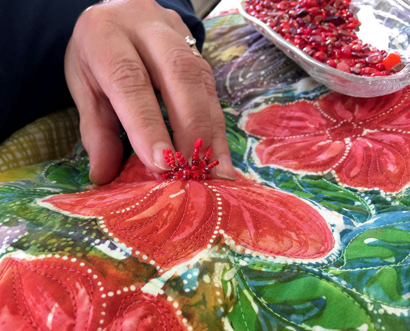 The beaded pistil stitch adds wonderful dimension to the center of the flower in this Hari Agung panel