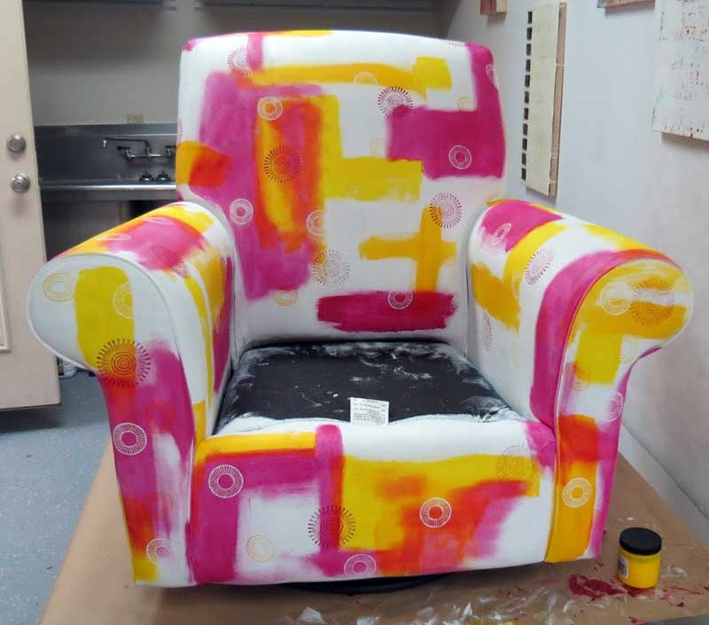 Stage 1 of transforming an upholstered chair with wooden printing blocks and fabric paint by fiber and mixed media artist Judi Hurwitt