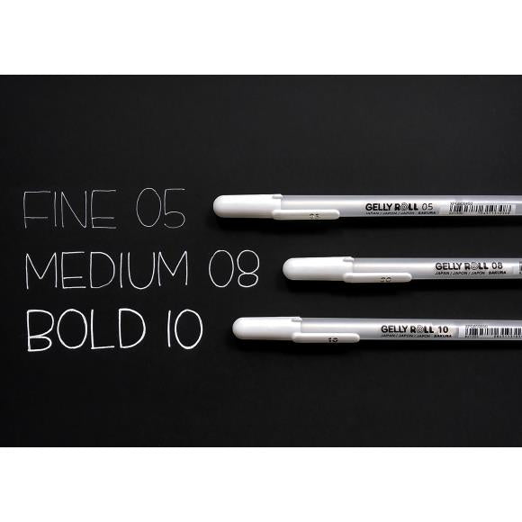 White pens and writing samples on a black surface.