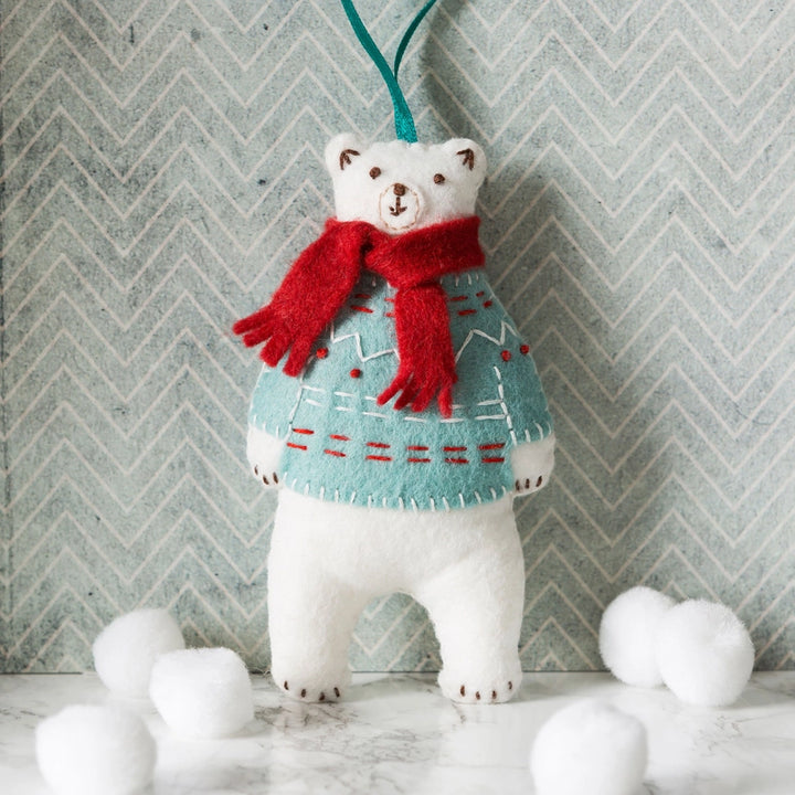 Polar bear Christmas ornament with red scarf and sweater.