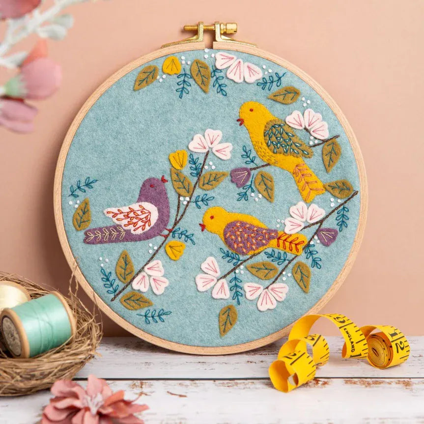Embroidery hoop with three birds and flowers.