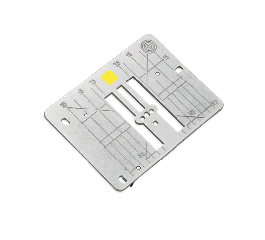Metal sewing machine plate with markings.