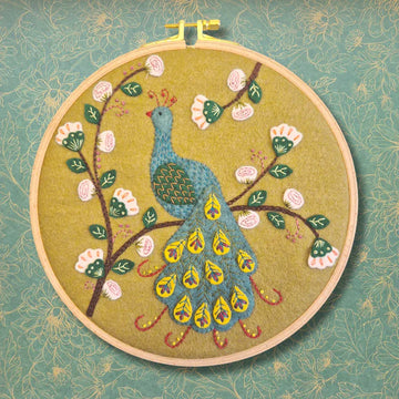 Embroidery hoop with a peacock and floral design.