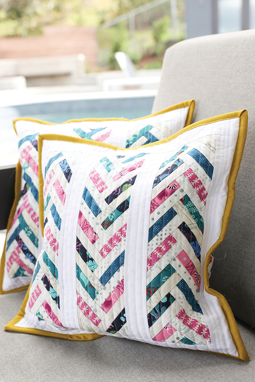Two patterned throw pillows with yellow trim.