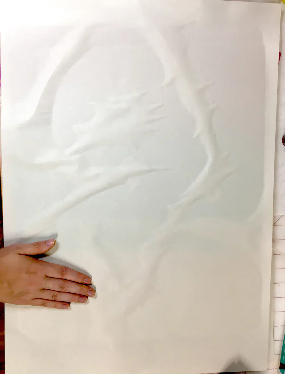 Close-up of hand on white paper with watermarks