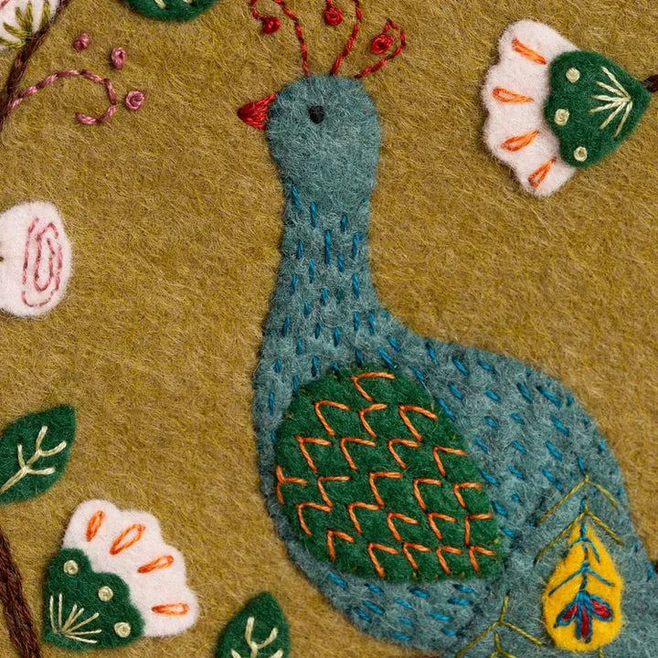 Embroidered peacock with floral accents.