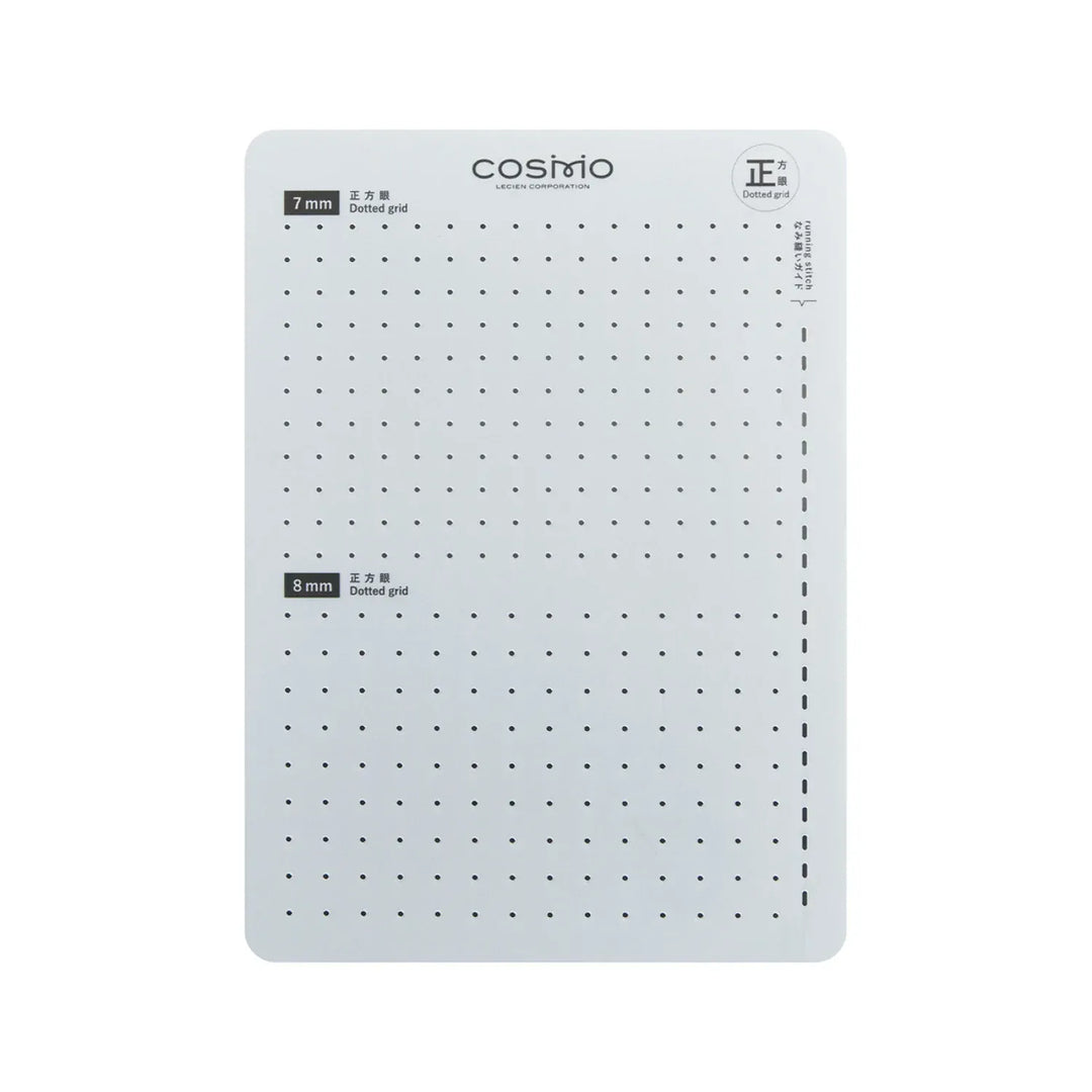 White gridded cutting mat with black dots.