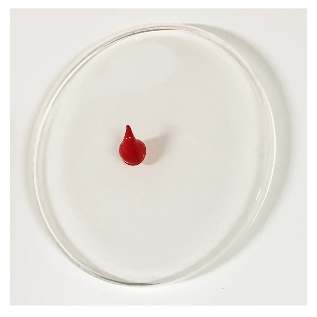 Red drop inside a clear circular container.