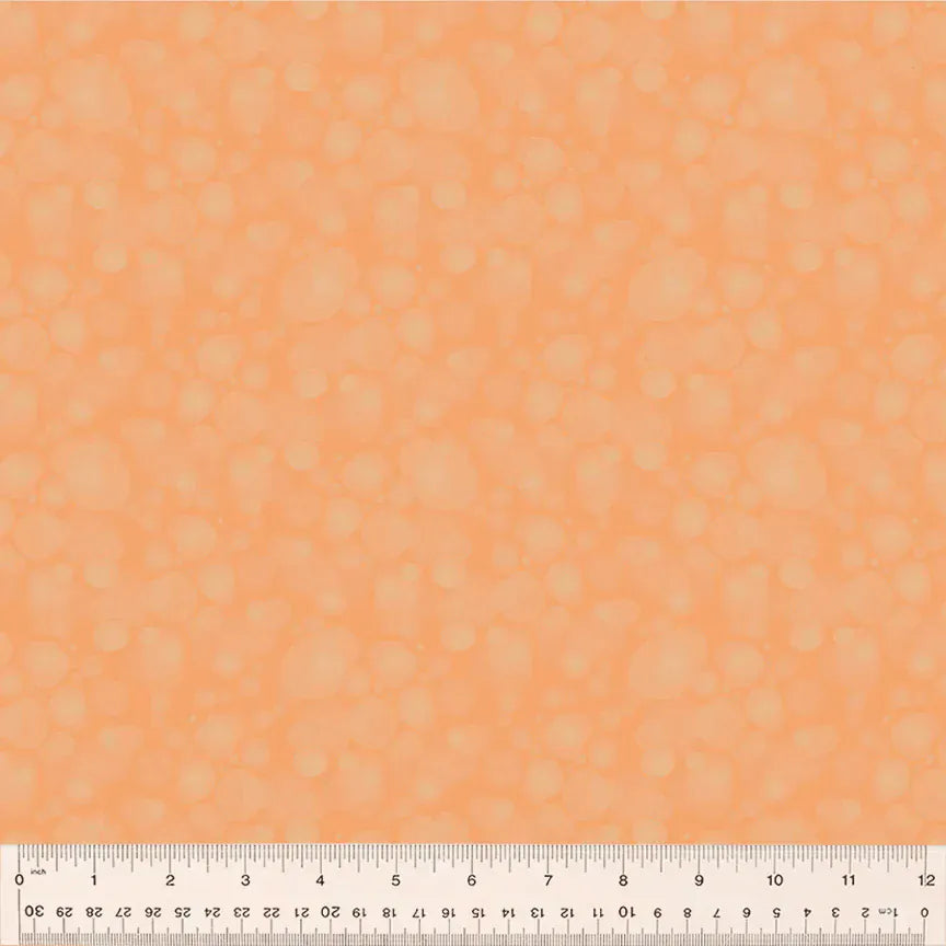 Orange fabric with faint circle pattern and ruler.