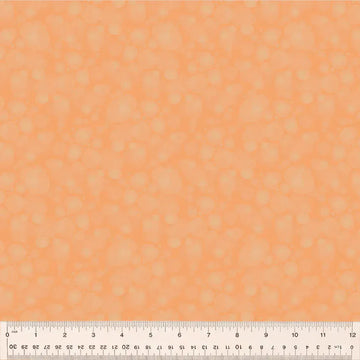 Orange fabric with faint circle pattern and ruler.