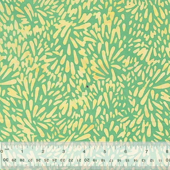 Green and yellow abstract fabric pattern with ruler.