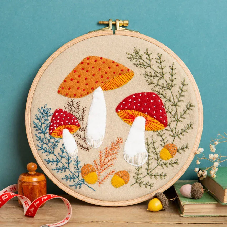 Embroidery hoop with mushroom and foliage design.