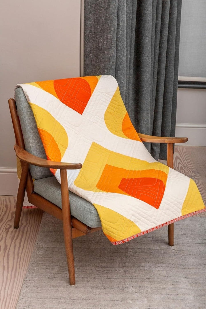 Orange & yellow geometric quilt on chair