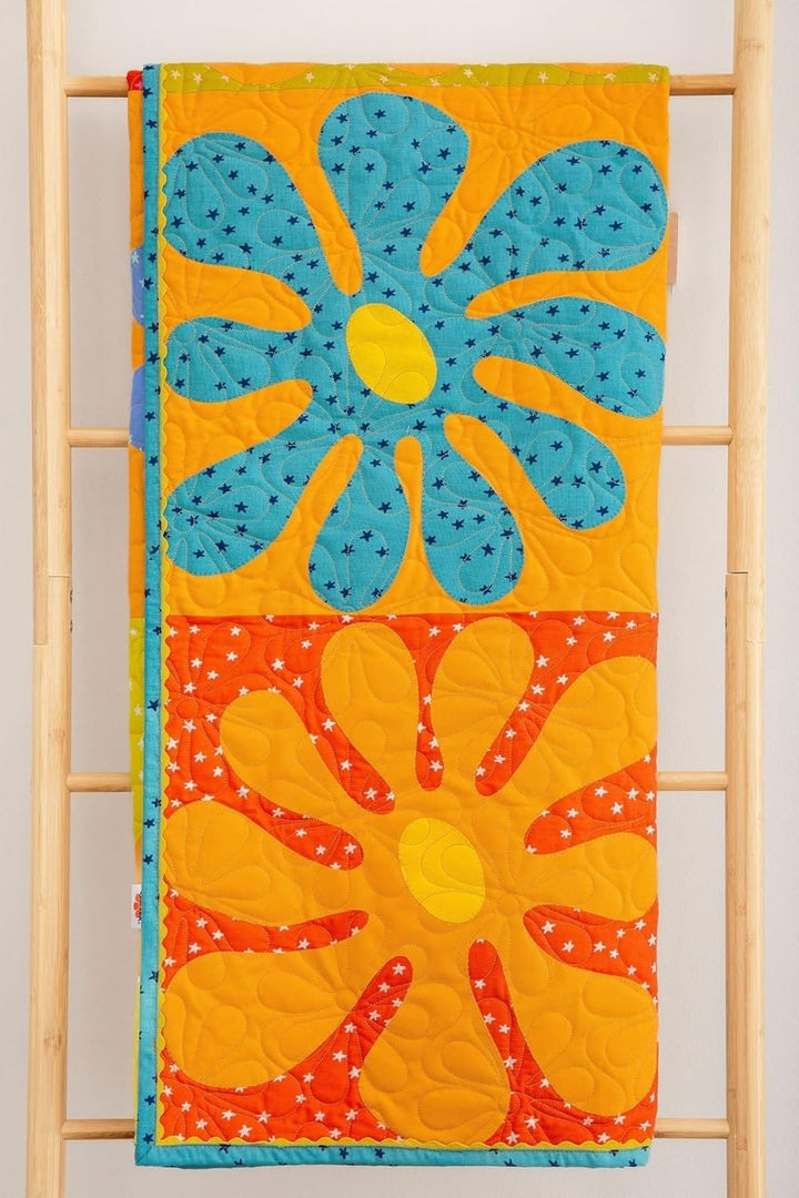 Colorful flower quilt on wooden ladder