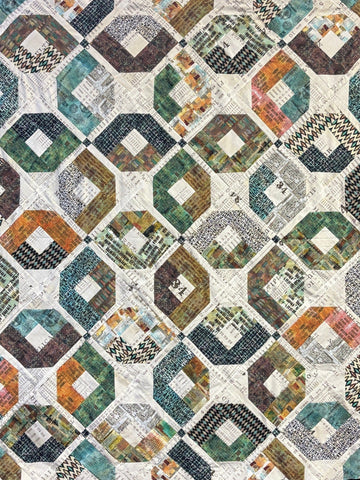 Geometric patchwork quilt in teal, orange, green, and brown.