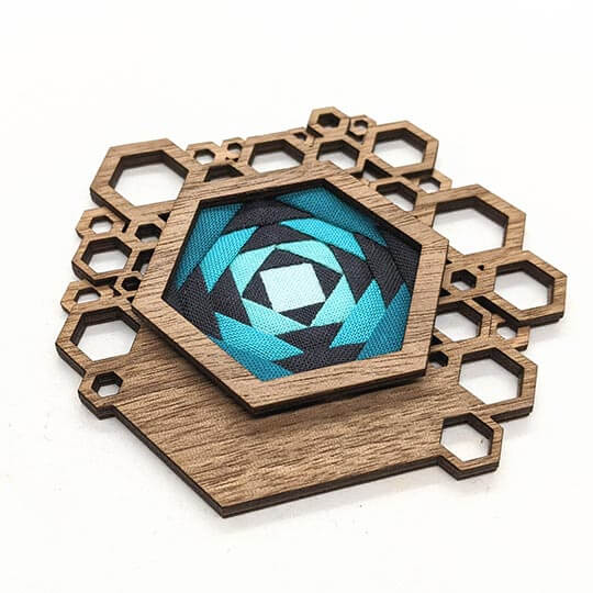 Hex brooch with geometric teal and black design