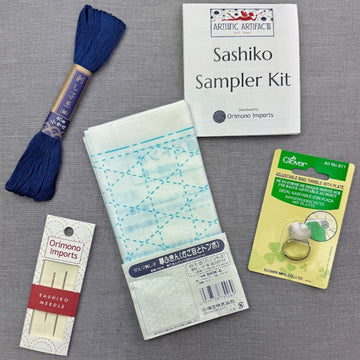 Sashiko embroidery kit with thread, needles, and sampler.