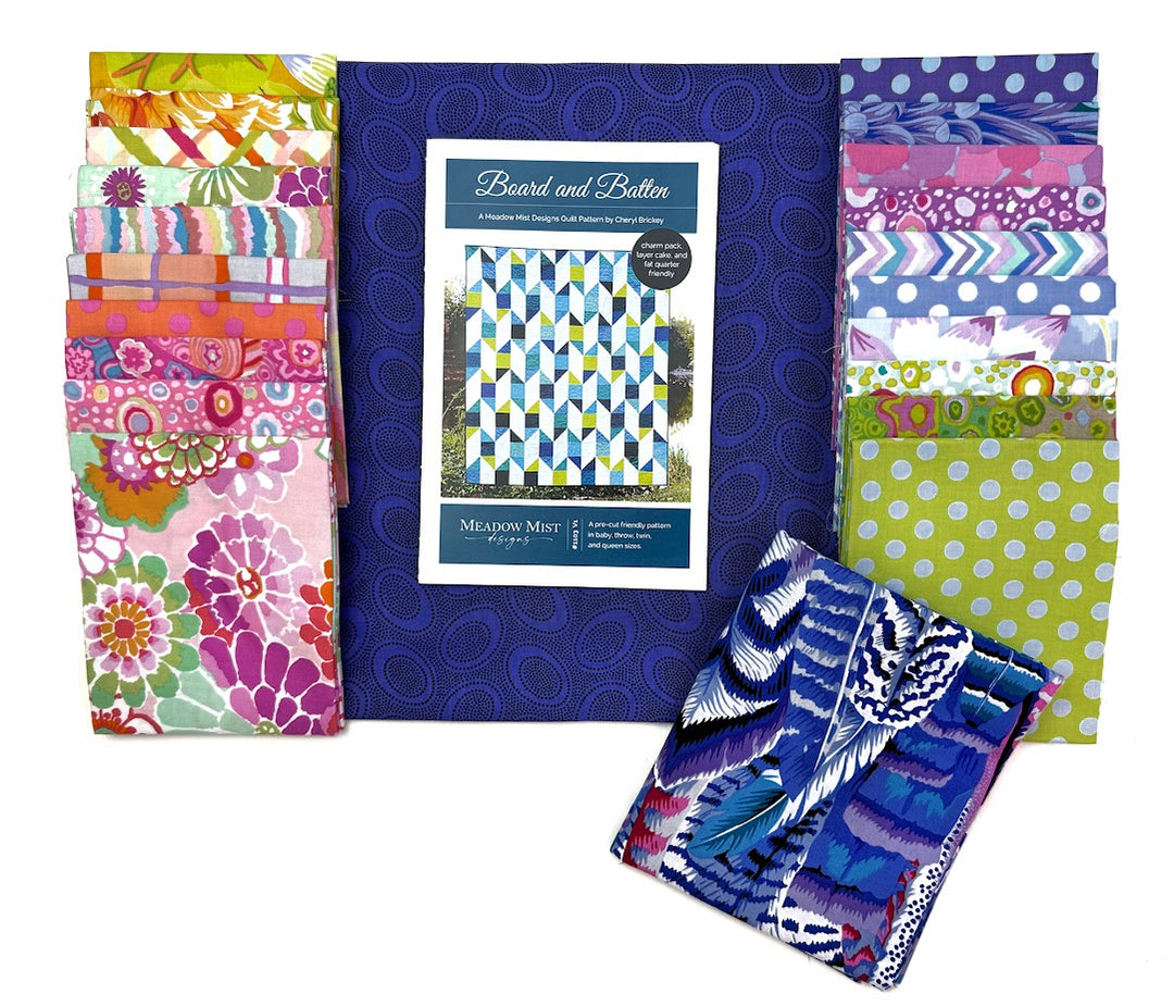 Stacks of colorful fabric and a book.