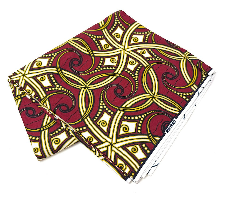 Folded fabric with red, yellow, and white geometric pattern.