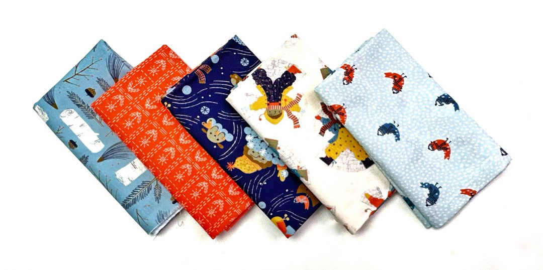 Five folded fabric squares with various patterns.