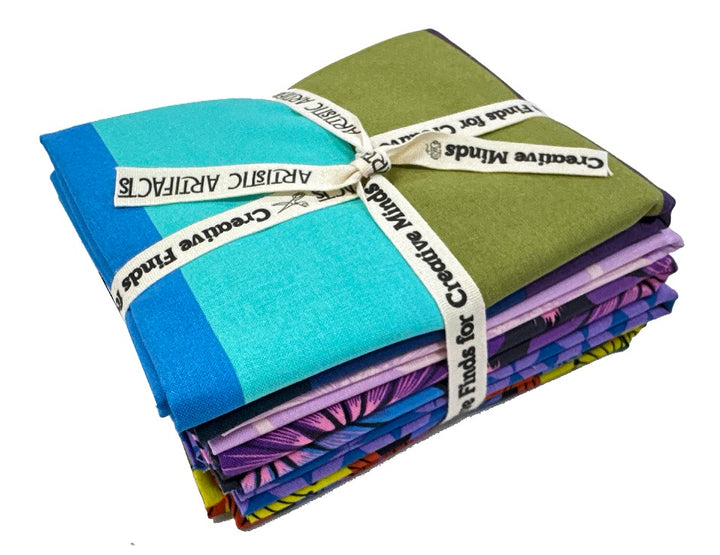 Stack of colorful fabric bundles tied with ribbon.