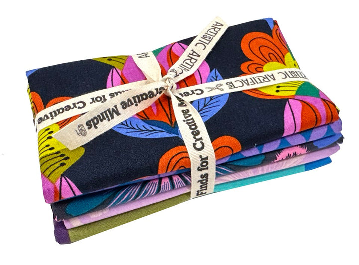 Stacked fabric bundles with floral prints, tied with ribbon.