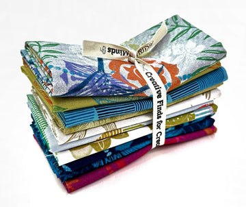 Stack of patterned fabric squares tied with a ribbon.