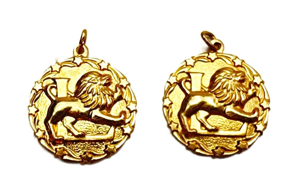 Two gold lion pendants.