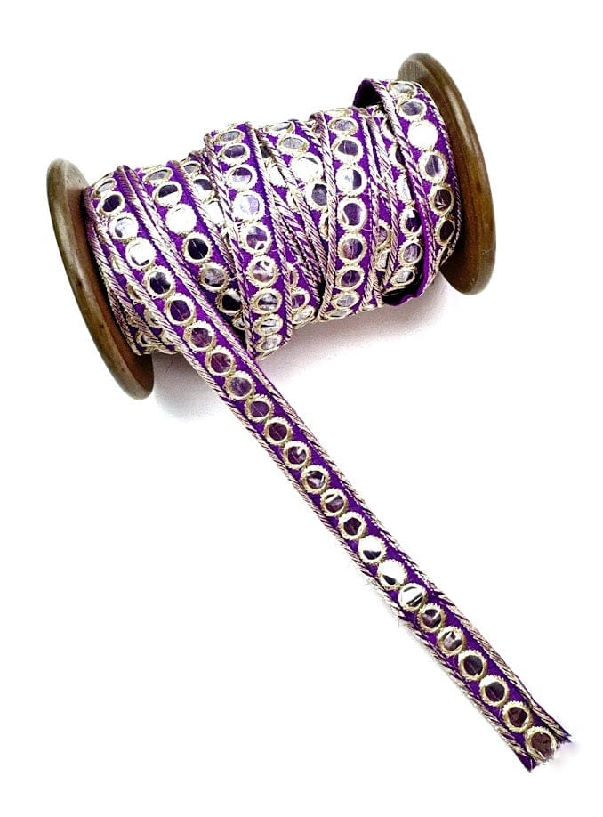 Spool of purple ribbon with silver circles.