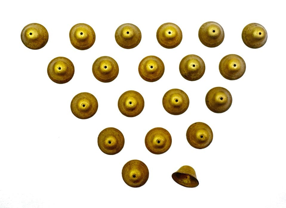 Arrangement of small, gold-colored bells on white background.
