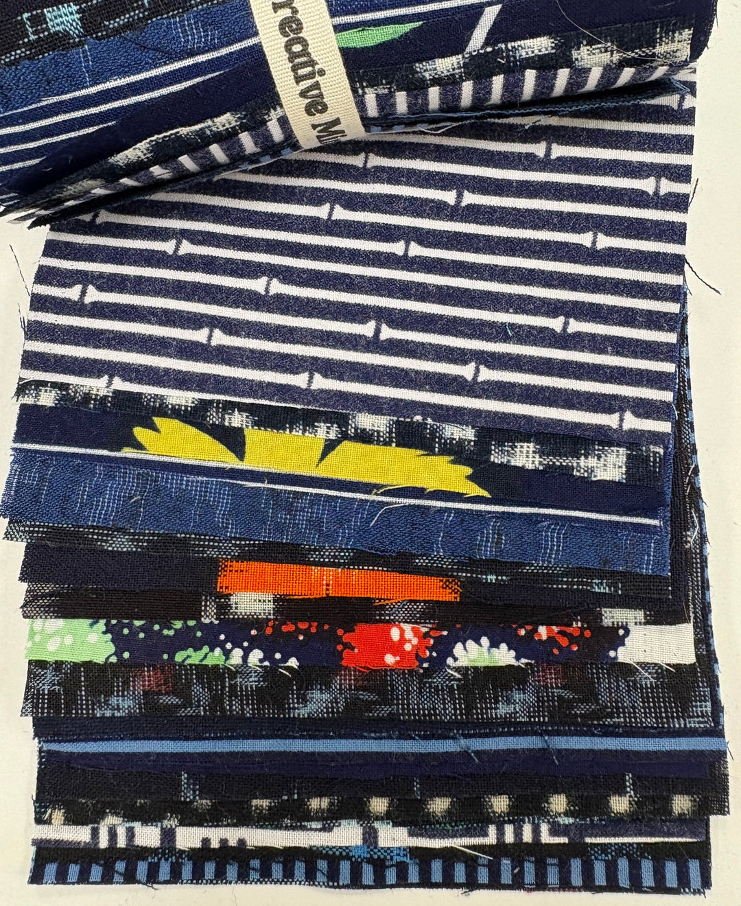 Stack of assorted blue and white patterned fabric swatches.