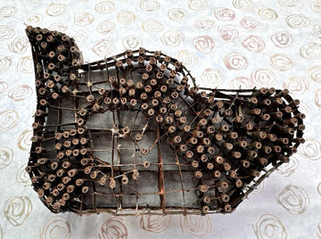 Decorative wall art shaped like a fish made from metal on a patterned background