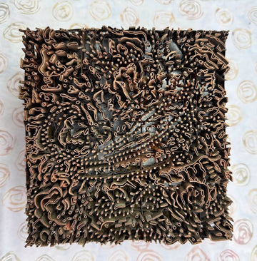 Decorative square piece with intricate patterns on a light background