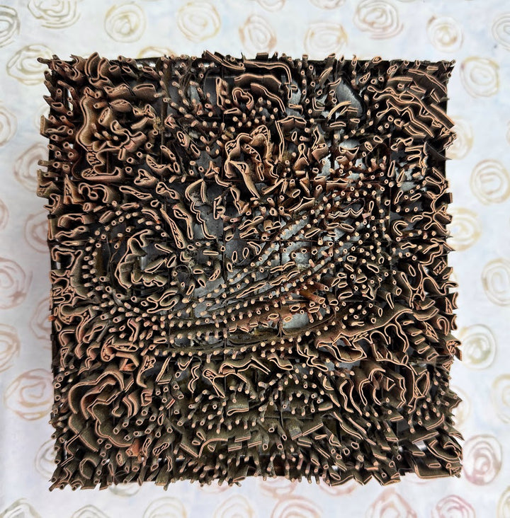 Decorative square piece with intricate patterns on a light background