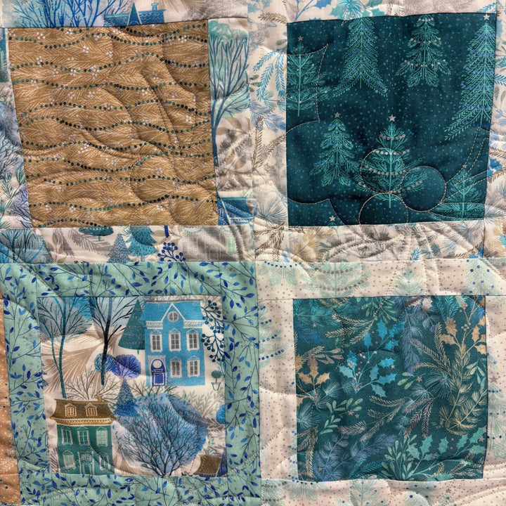 Peaceful quilt with houses, trees, and winter scenes