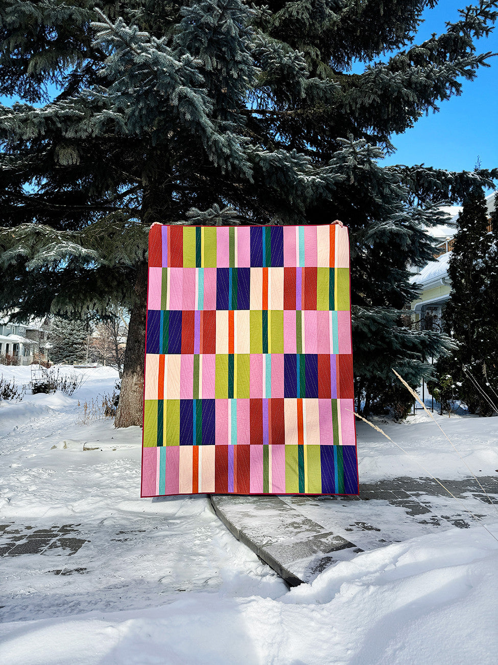 Colorful quilt displayed outdoors in winter