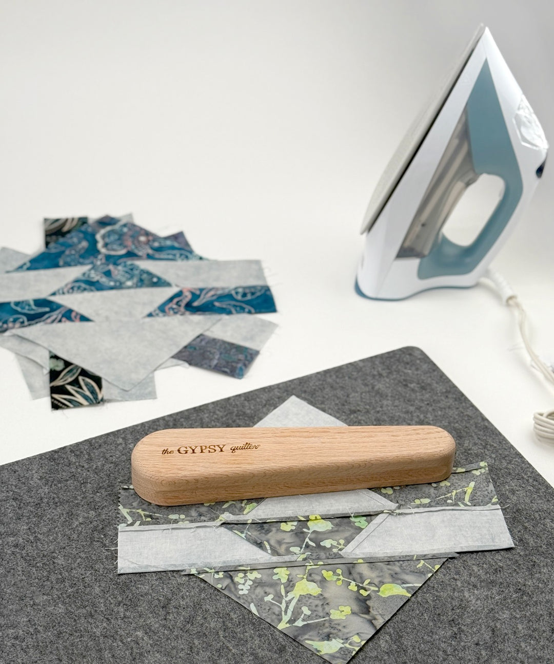 Quilting process with iron, fabric, and wooden press.