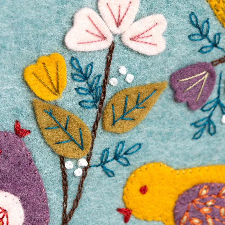 Embroidered felt flower and bird design.