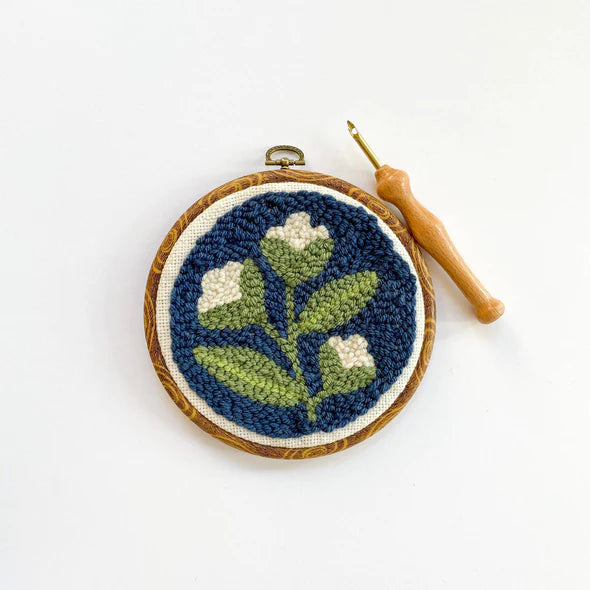Punch needle embroidery with floral design and hook.
