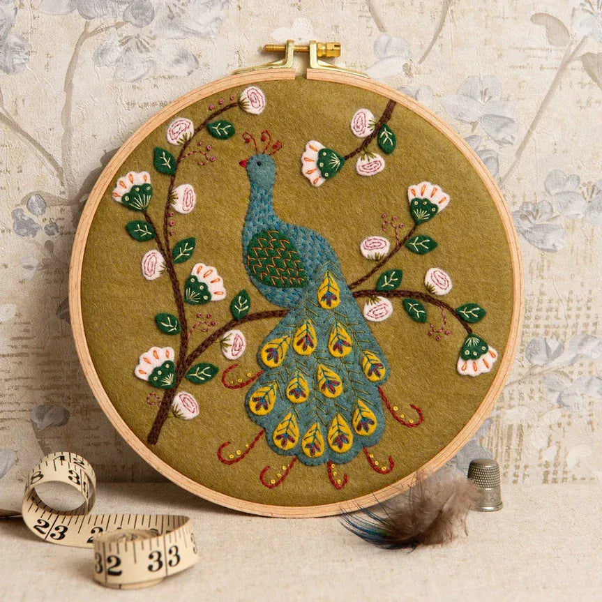 Embroidery hoop with peacock and floral design.