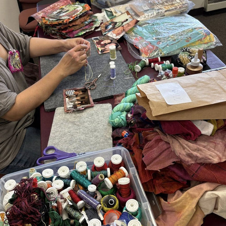 artist sewing with fabric and thread.