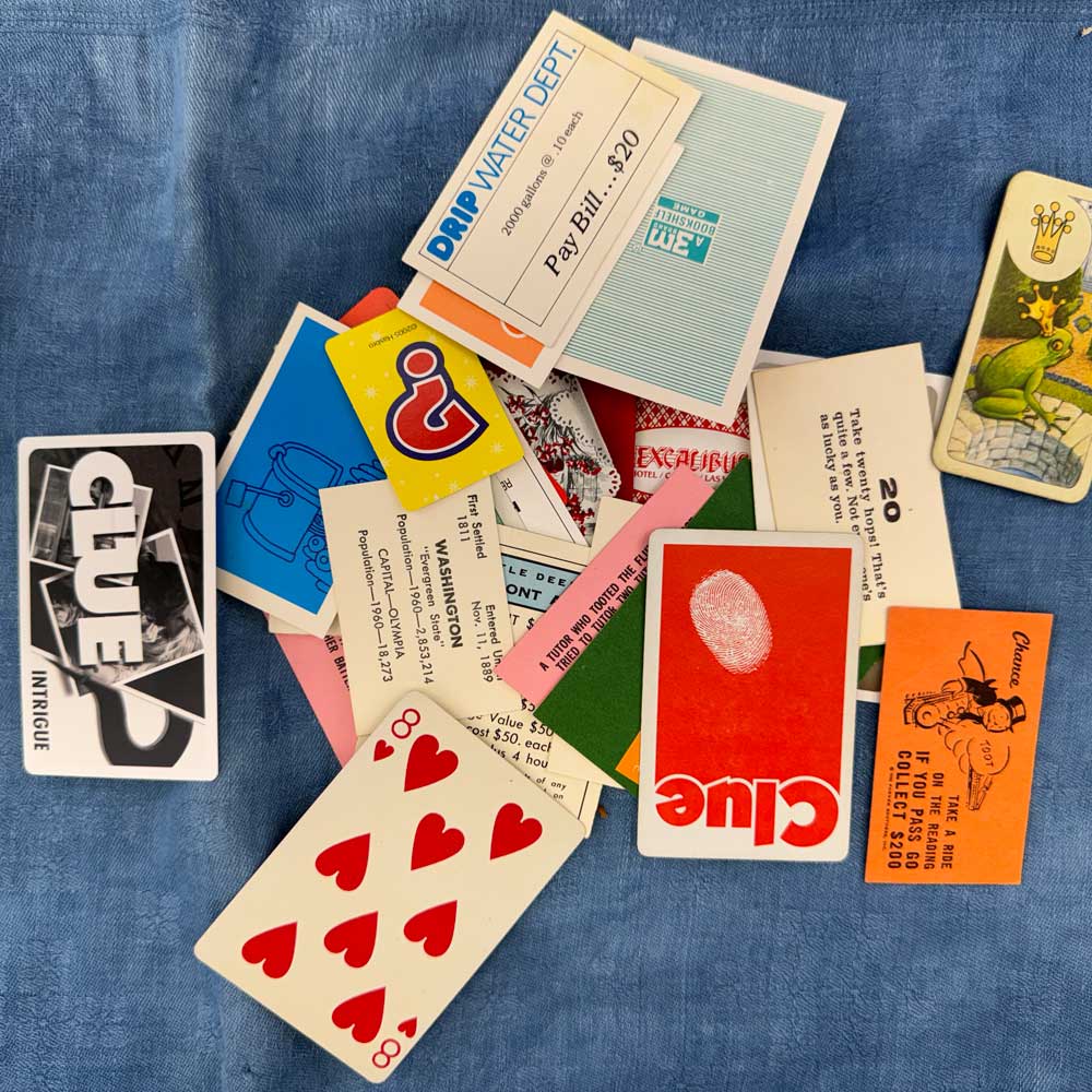 Game card assortment with Clue, Monopoly, and other game cards