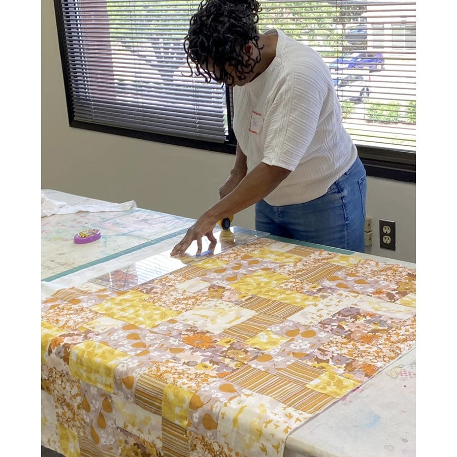 Pre-beginner student cutting quilt fabric.